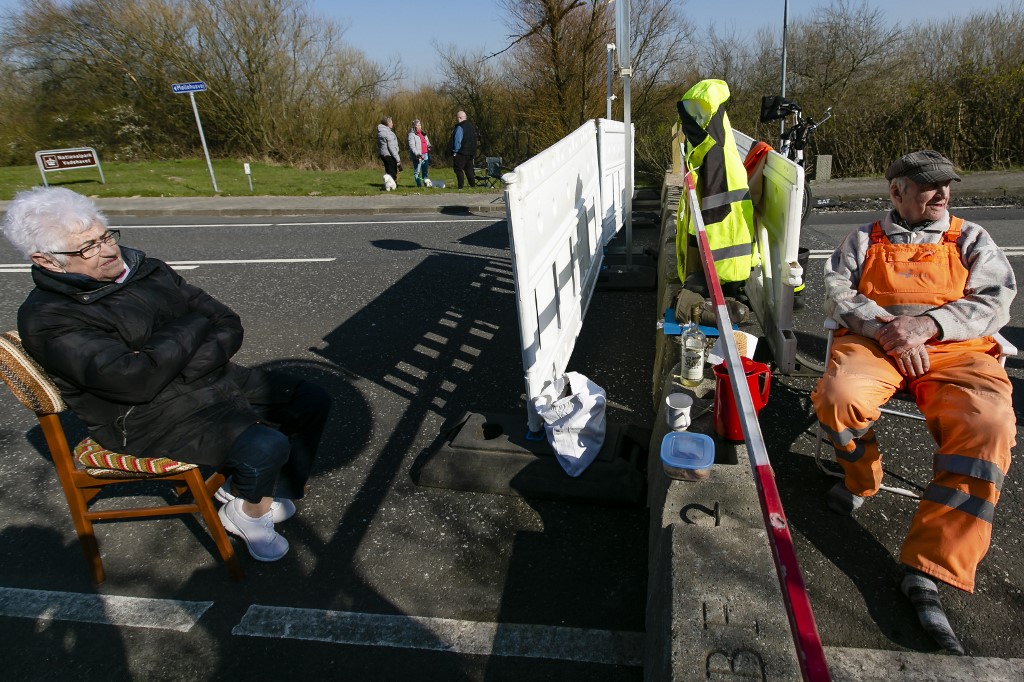 27 March 2020, Schleswig-Holstein, Aventoft: Karsten T�chsen Hansen (r) and the Danish Inga Rasmussen are sitting at the German-Danish border crossing. Because of the corona virus the couple is currently not allowed to visit each other. Photo: Frank Molter/dpa